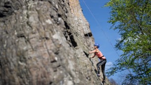 Mid adult woman climbing rocks outdoors in nature, an active lifestyle.
