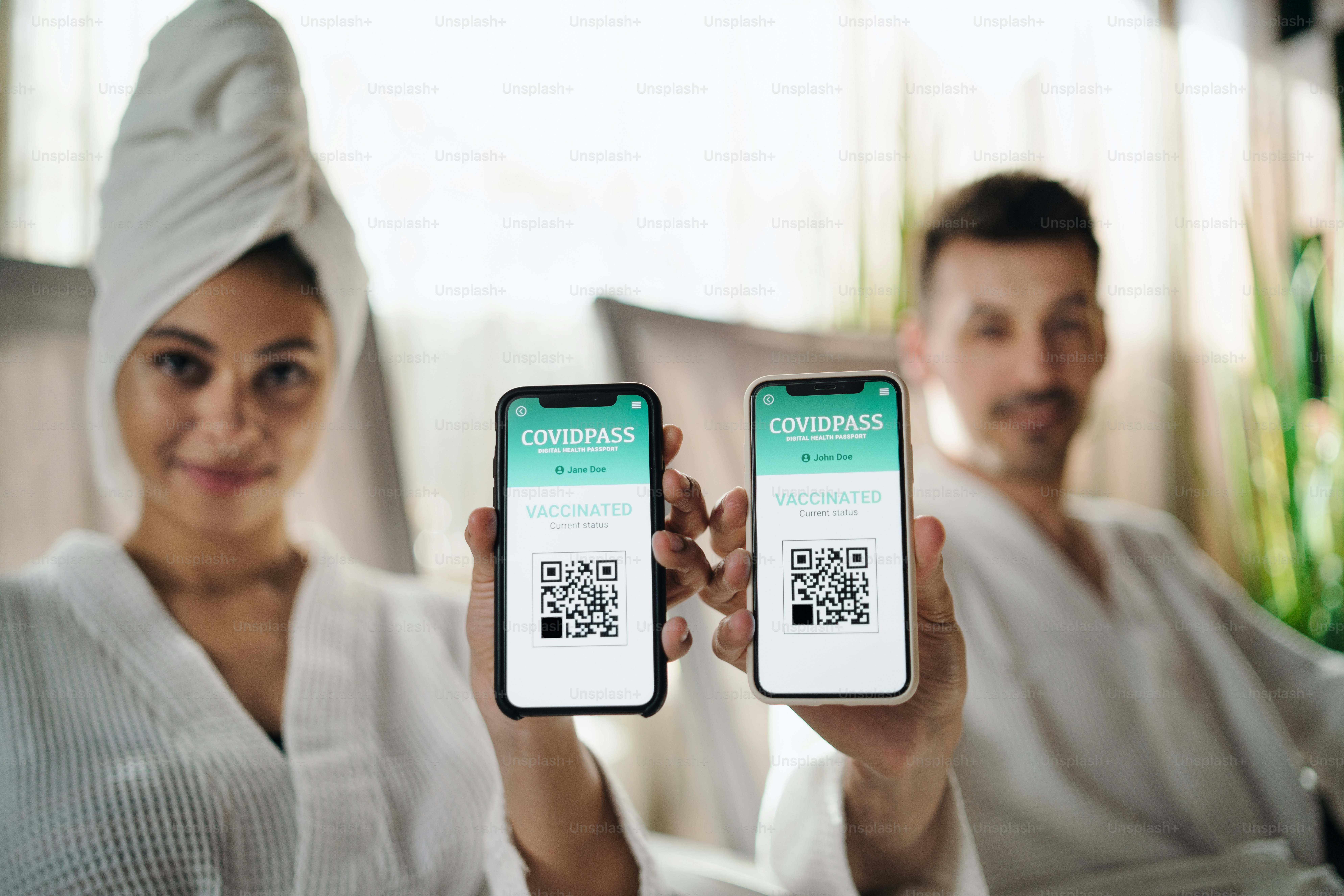 A portrait of young couple sitting and relaxing in spa resort, coronavirus and vaccination concept.