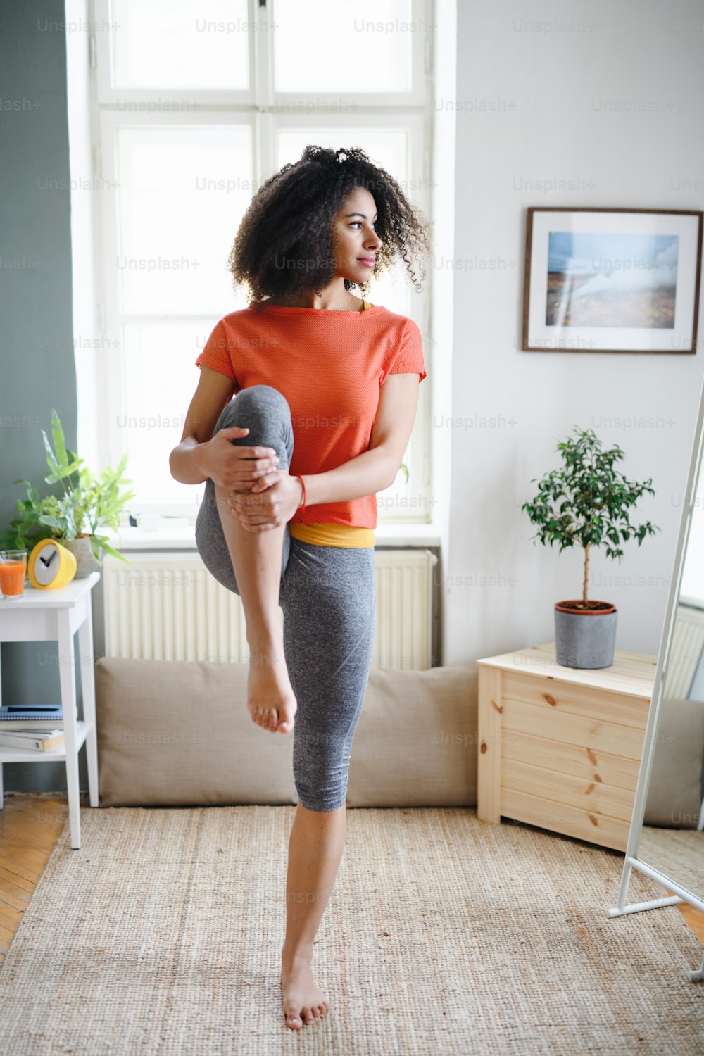 Happy young woman indoors at home, doing exercise. Sport concept.