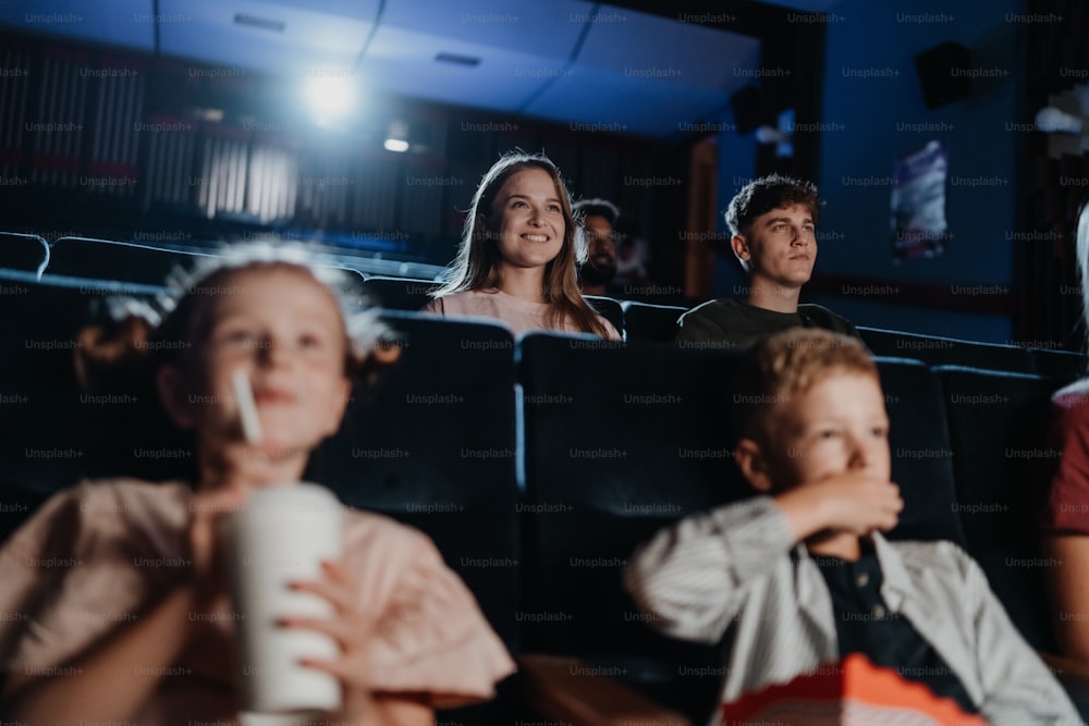 Um jovem casal alegre no cinema, assistindo a um filme.