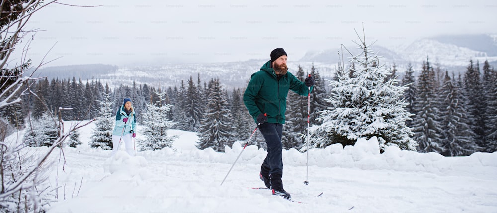 Active mature couple cross country skiing outdoors in winter nature, Tatra mountains Slovakia.