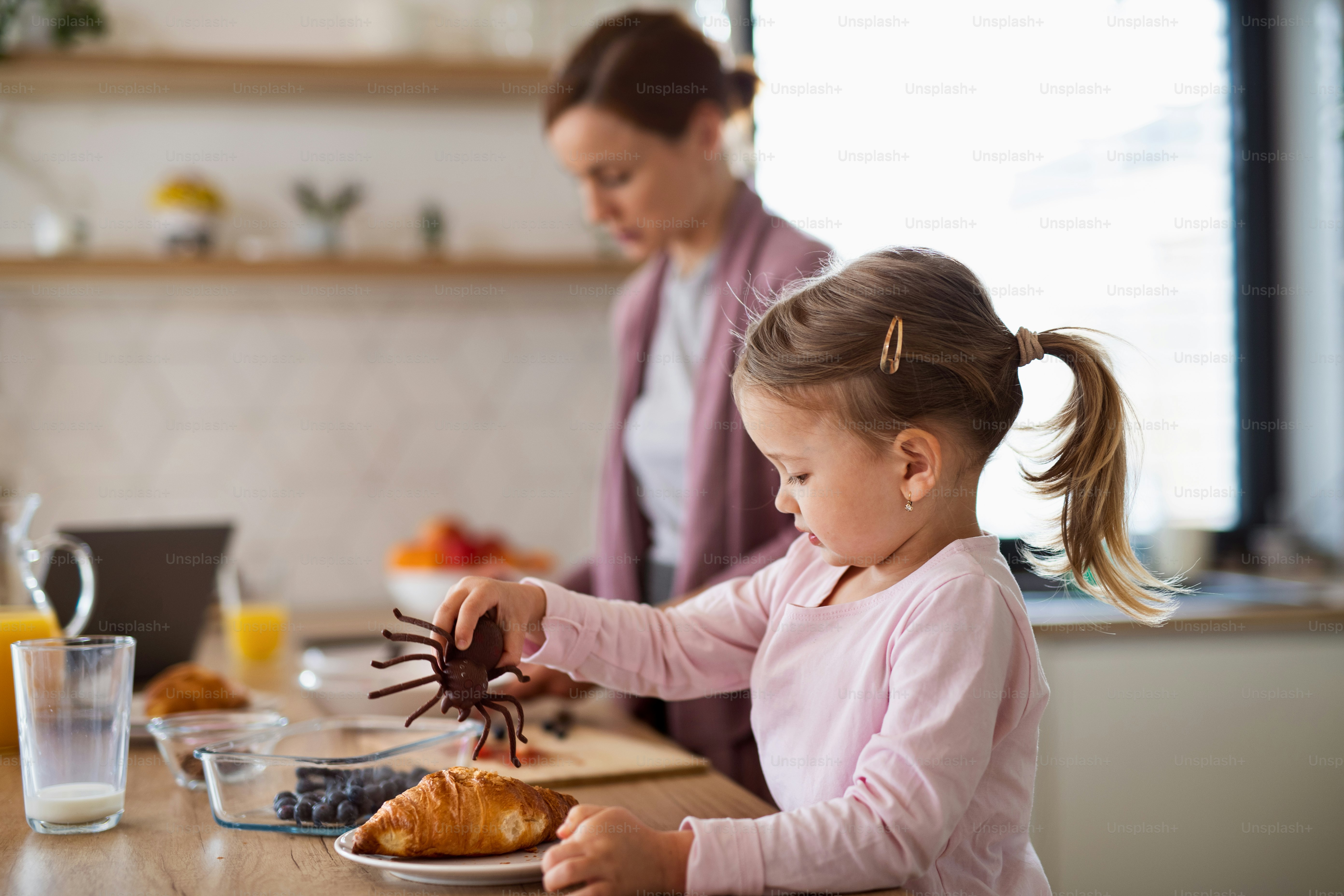 Madre feliz con hija pequeña en el interior de la cocina en casa ...