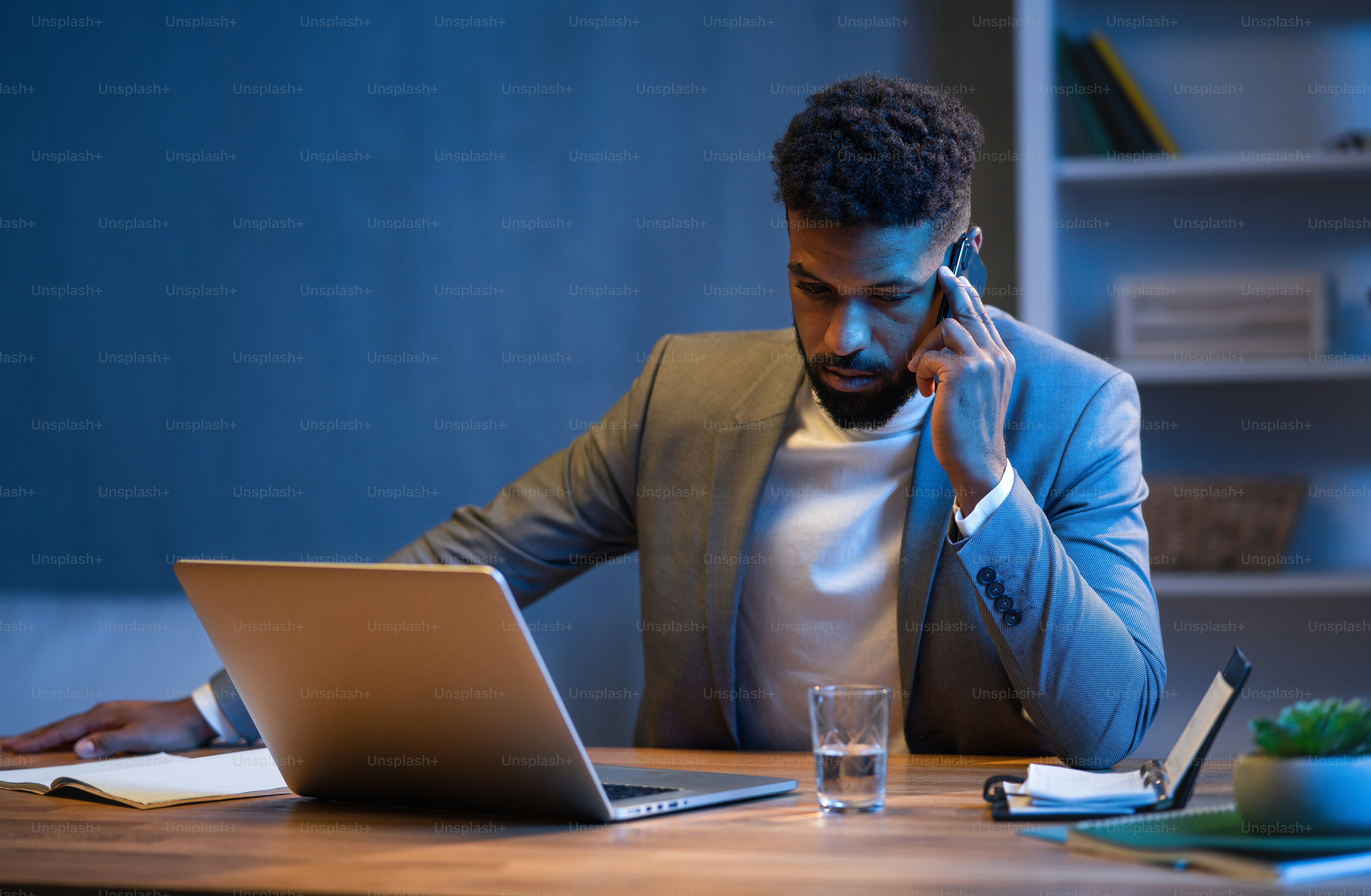 Un jeune homme d'affaires afro-américain passe un appel téléphonique à  l'intérieur dans un bureau la nuit. photo – Image de Bureau sur Unsplash, image size:3000x1961