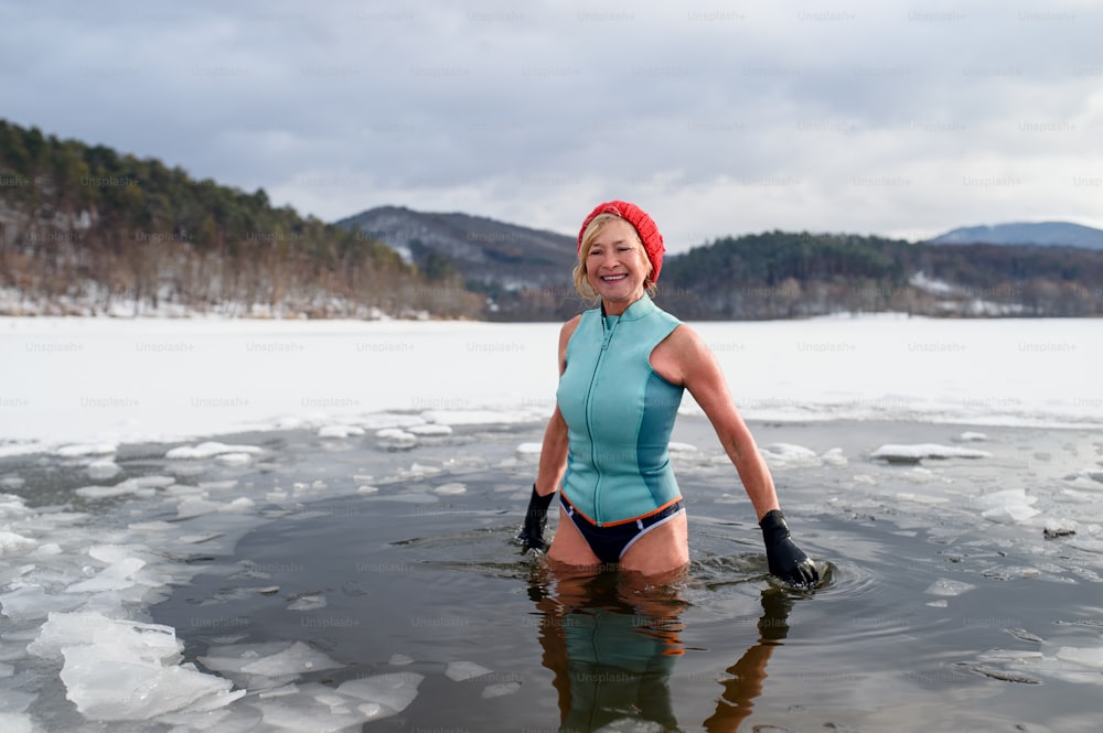 겨울에 야외에서 수영복을 입은 활동적인 노인 여성의 초상화, 감기 치료 개념.