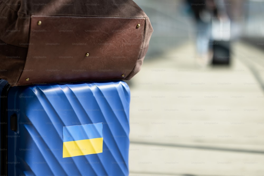 A suitcase on railway. Stand with Ukraine. Ukrainian people leaving from the war. Ukrainian refugees concept.