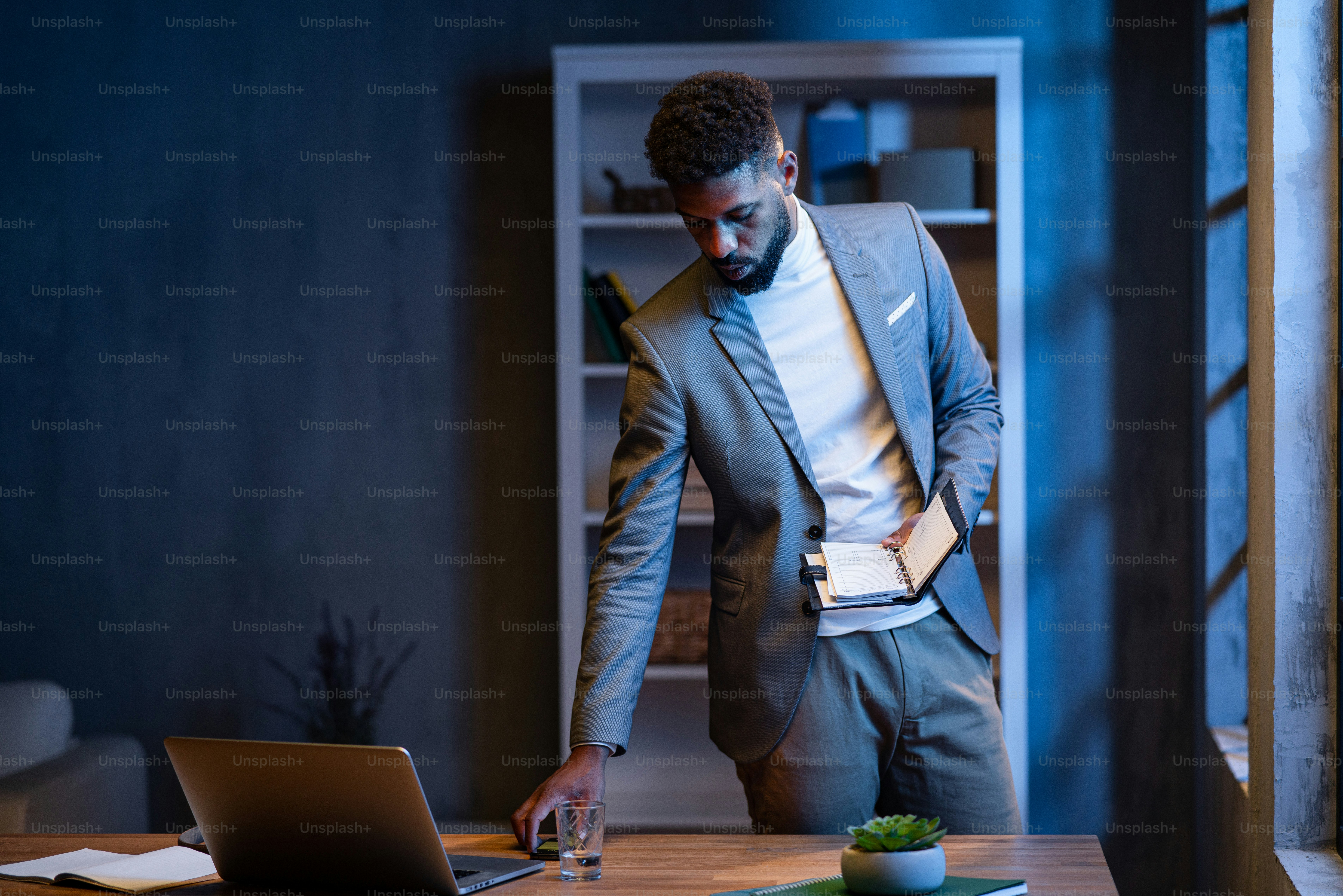 Un jeune homme d'affaires afro-américain avec un journal intime à  l'intérieur dans un bureau la nuit. photo – Image de Affaire sur Unsplash, image size:3000x2001