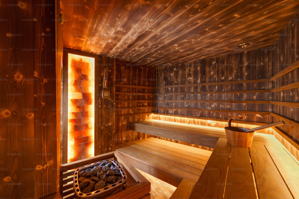 An empty wooden steam room with stone heater