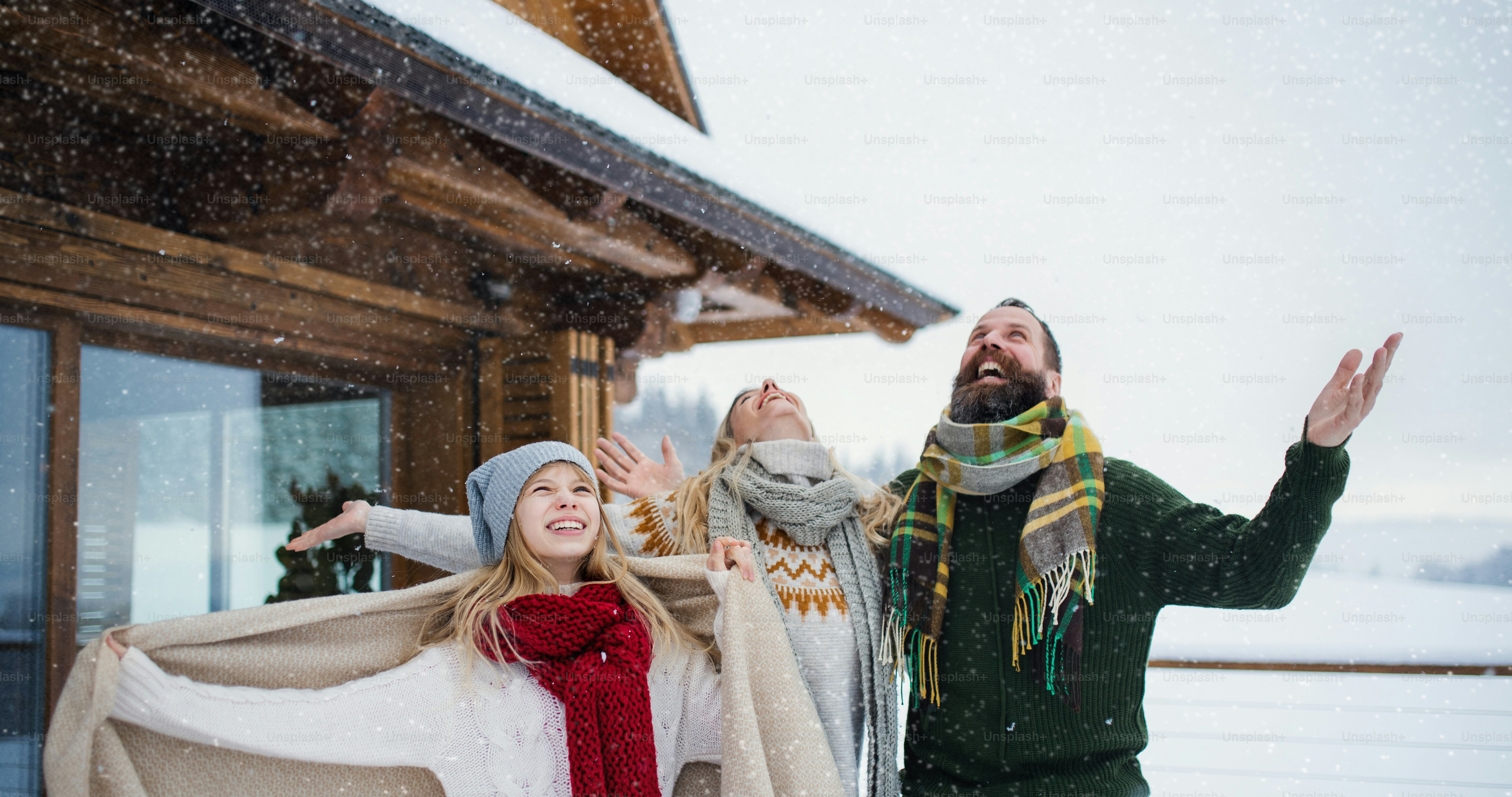 Happy family with small daughter having fun on terrace outdoors, holiday in winter nature.