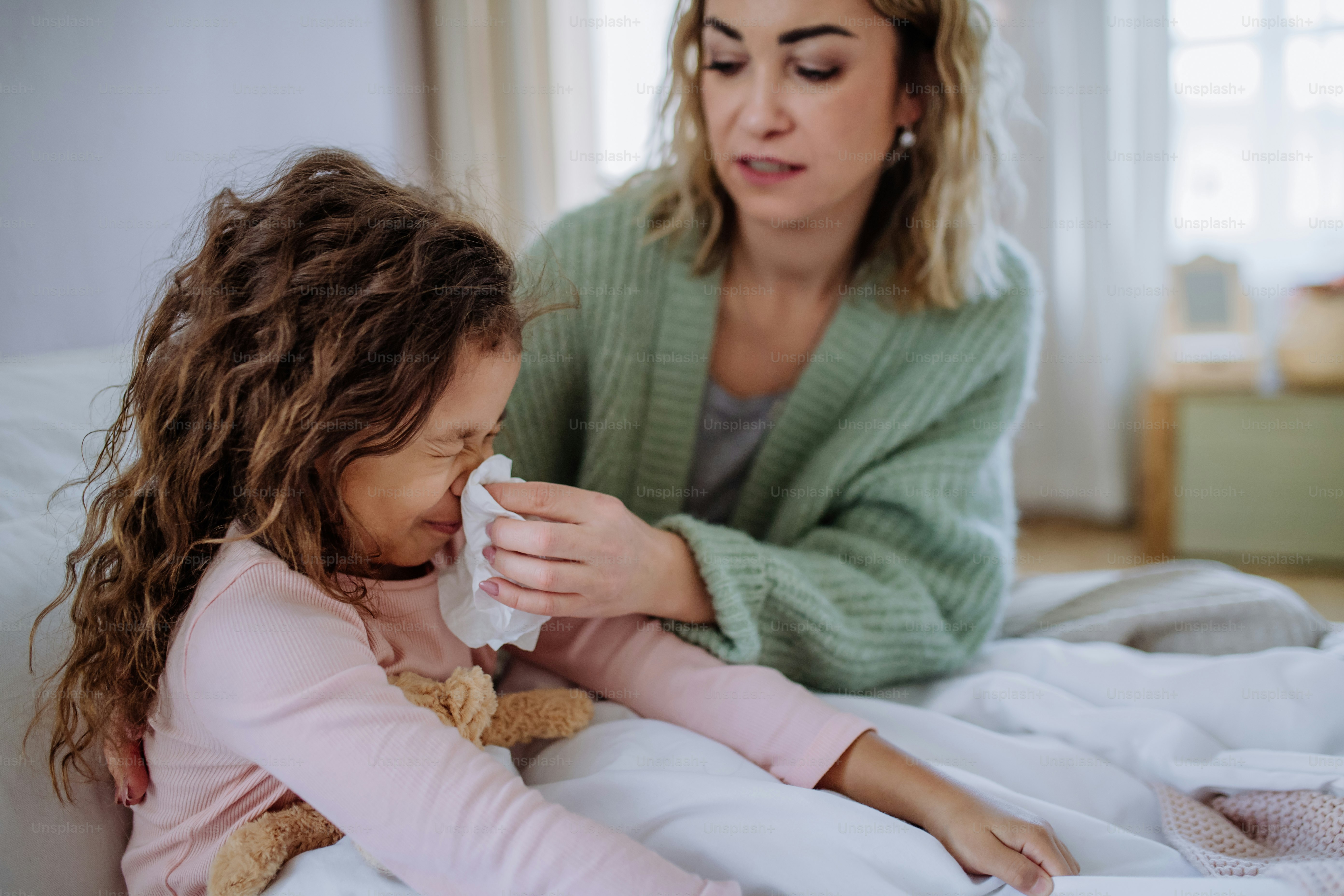 Una madre cuidando a su hija enferma en casa.