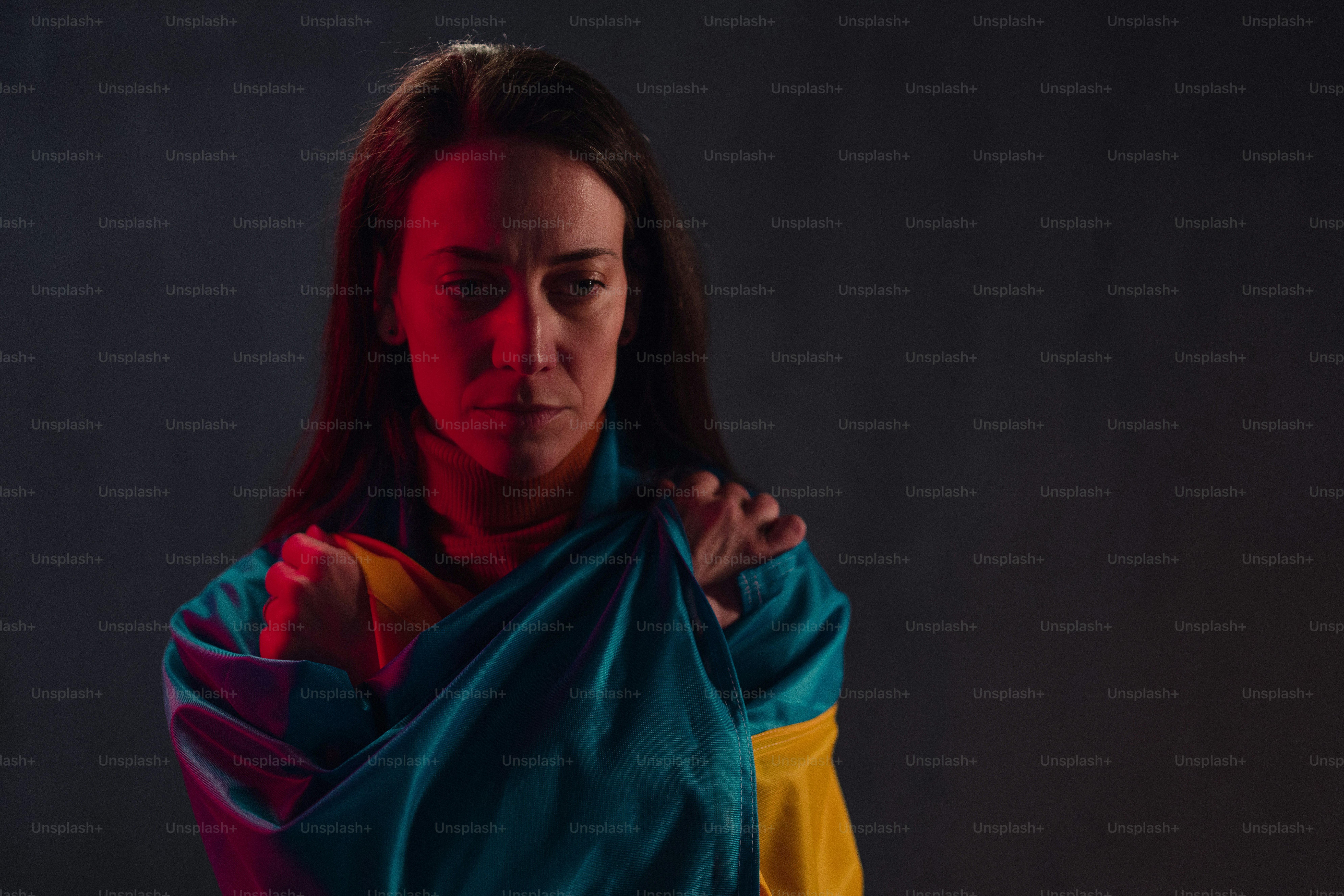 Mujer triste cubierta con la bandera de Ucrania