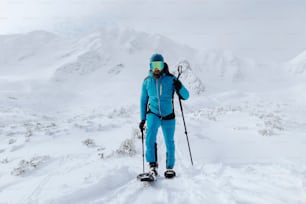 Un skieur de randonnée alpin au sommet d’un sommet enneigé dans les Alpes suisses