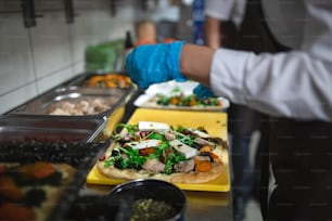 A close-up of cook preparing meal in commercial kitchen.
