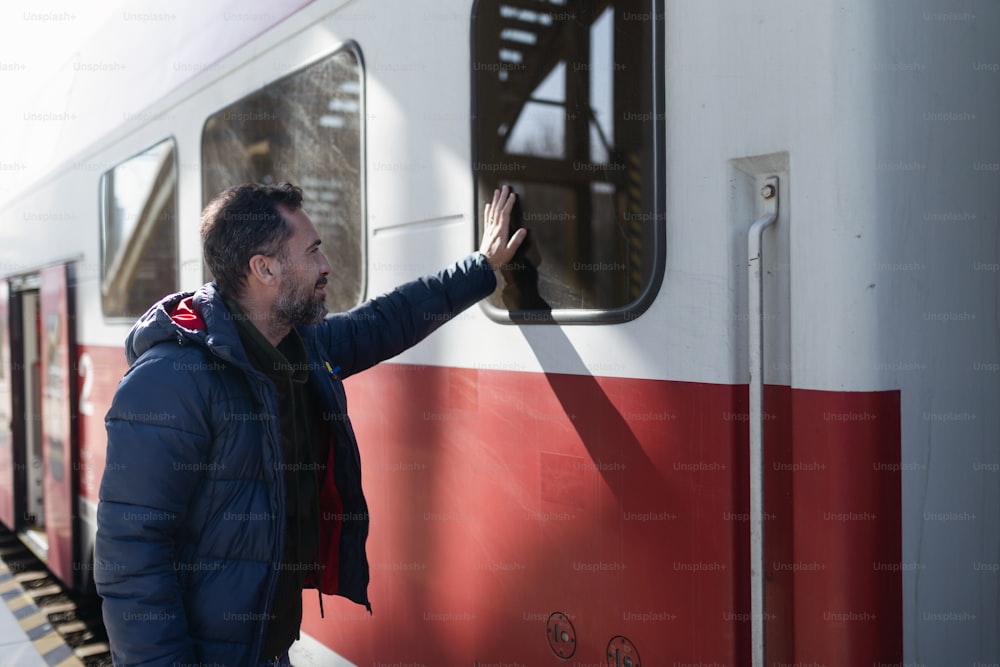 우크라이나에서 러시아의 침공으로 우크라이나를 떠나는 기차에서 작별 인사를하고 가족에게 손을 흔드는 우크라이나 남자.