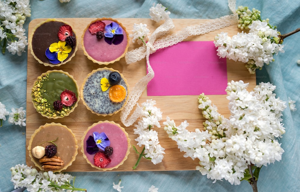 Uma vista superior da seleção de sobremesas de bolo coloridas e deliciosas em caixa sobre a mesa.