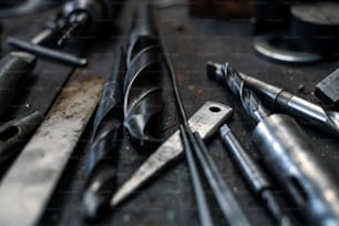 Um close up de ferramentas industriais dentro de casa em oficina de metal.