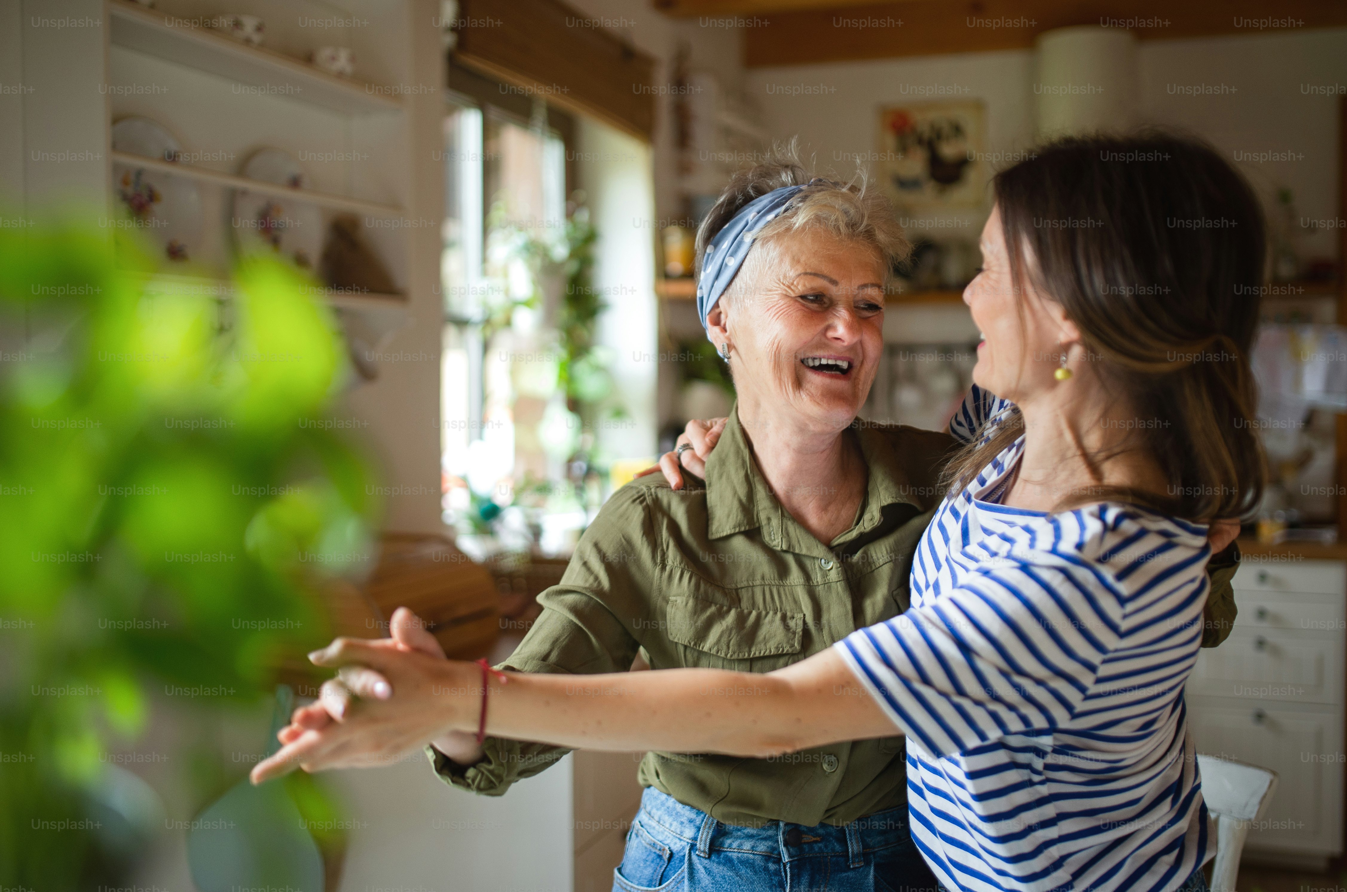 Caregiver reviewing medical alert system costs with elderly parent at kitchen table