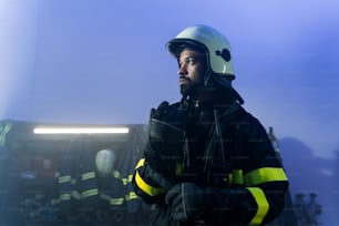 A young African-American firefighter in fire station at night.