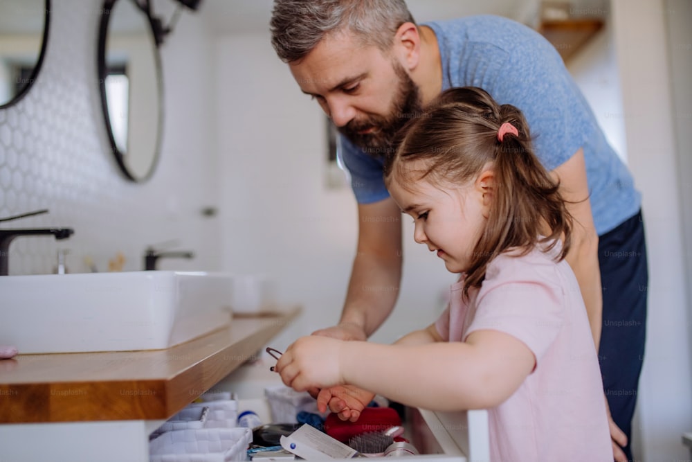 Un padre feliz con su pequeña hija en el baño, concepto de rutina matutina.