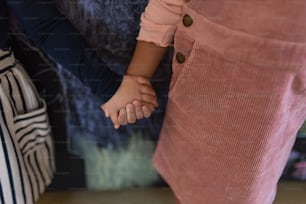 A close-up of ittle girls standing in front of blackboard and holding hands