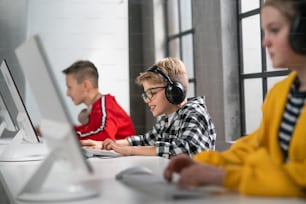 Niños en edad escolar usando la computadora en un aula en la escuela