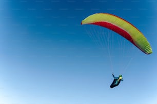 A paraglider in the blue sky. The sportsman flying on a paraglider.