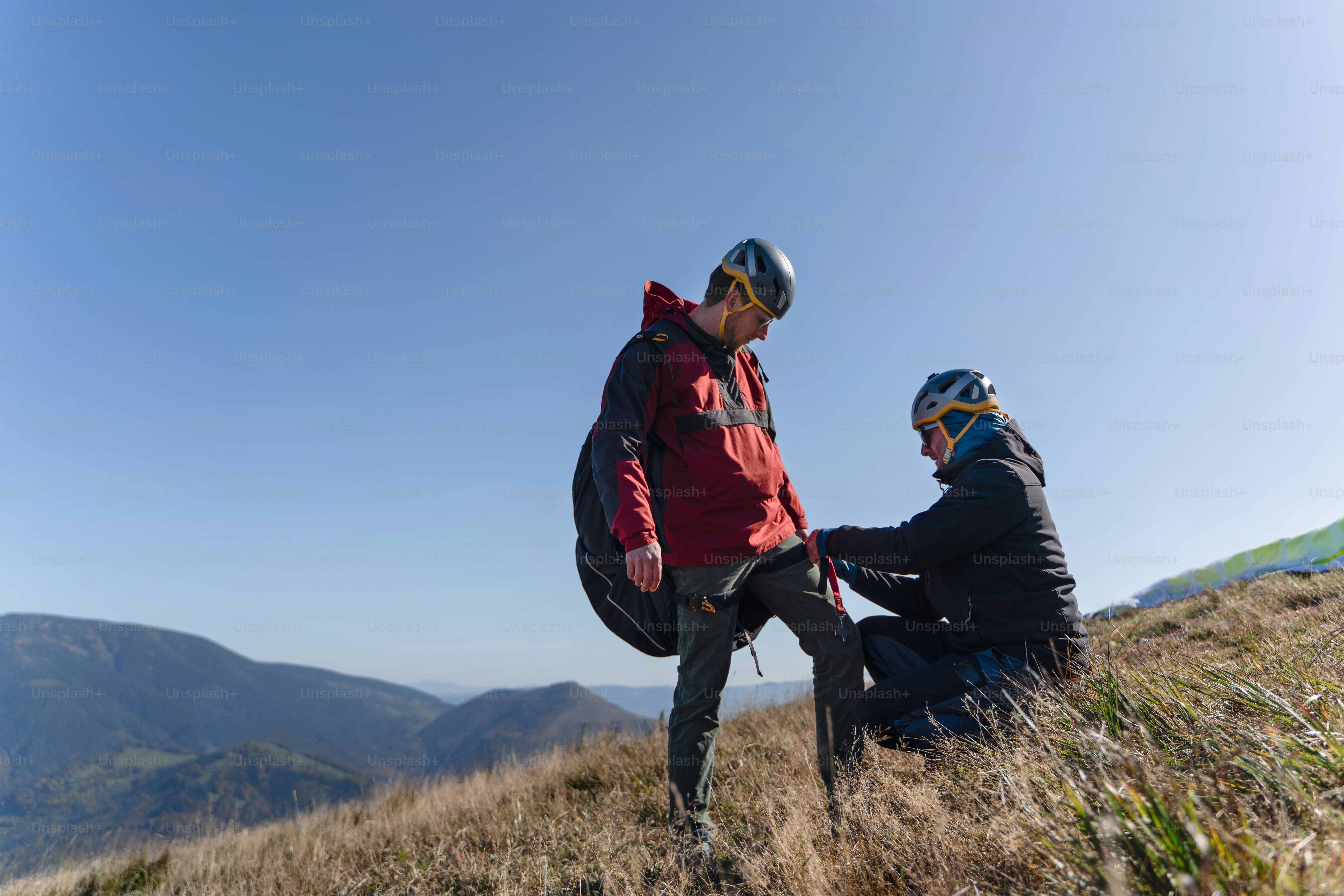 Ein Mann, der dem Gleitschirmpiloten hilft, sich auf den Flug vorzubereiten.