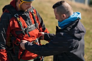 Un uomo che aiuta il pilota di parapendio a prepararsi per il volo.