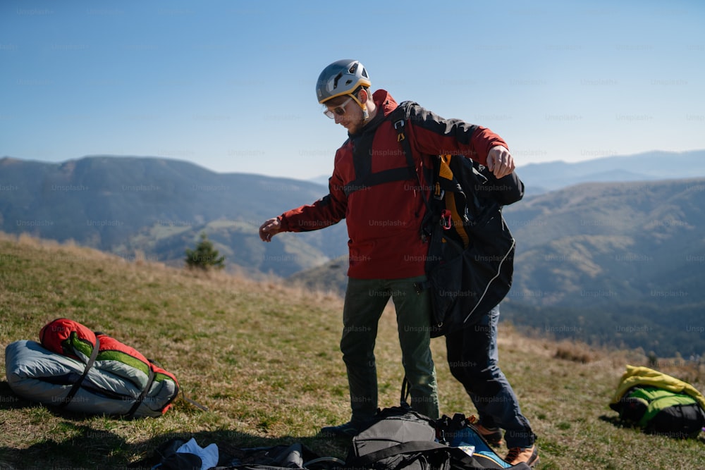 A man helping paragliding pilot to prepare for flight.
