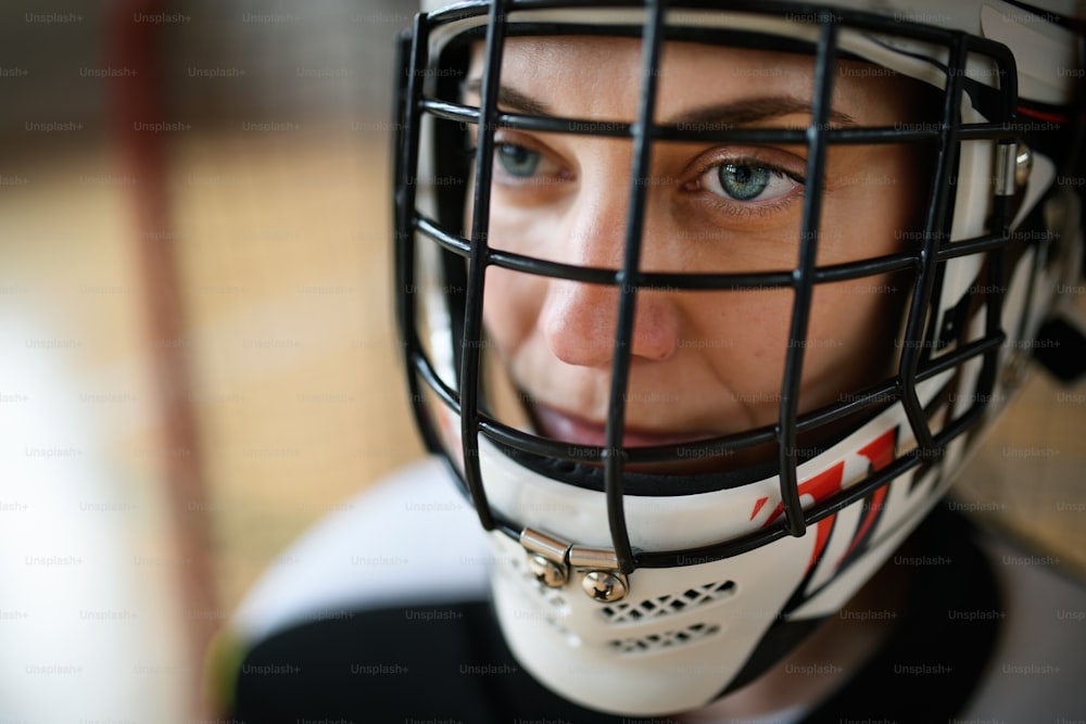 Eine Nahaufnahme der Unihockey-Torhüterin im Helm, die sich auf das Spiel im Fitnessstudio konzentriert.