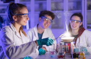 Estudantes de ciências animados fazendo um experimento químico no laboratório da universidade.