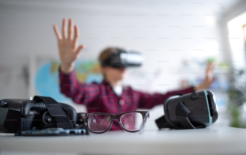 Un étudiant heureux portant des lunettes de réalité virtuelle à l’école en cours d’informatique, gros plan sur des lunettes.