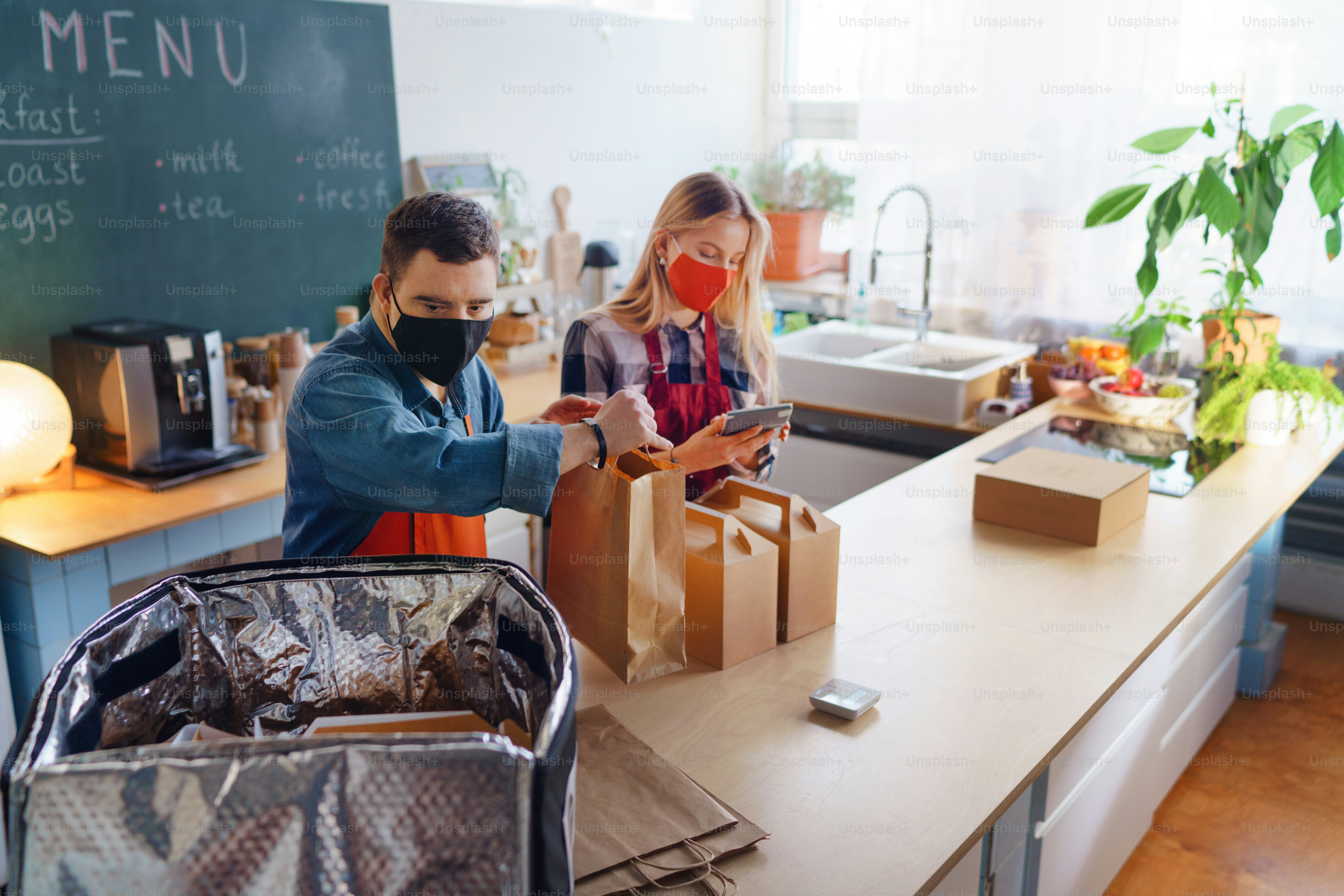 젊은 다운 증후군 웨이터가 식당, 사회적 포용 개념에서 동료와 함께 일하고 있습니다.