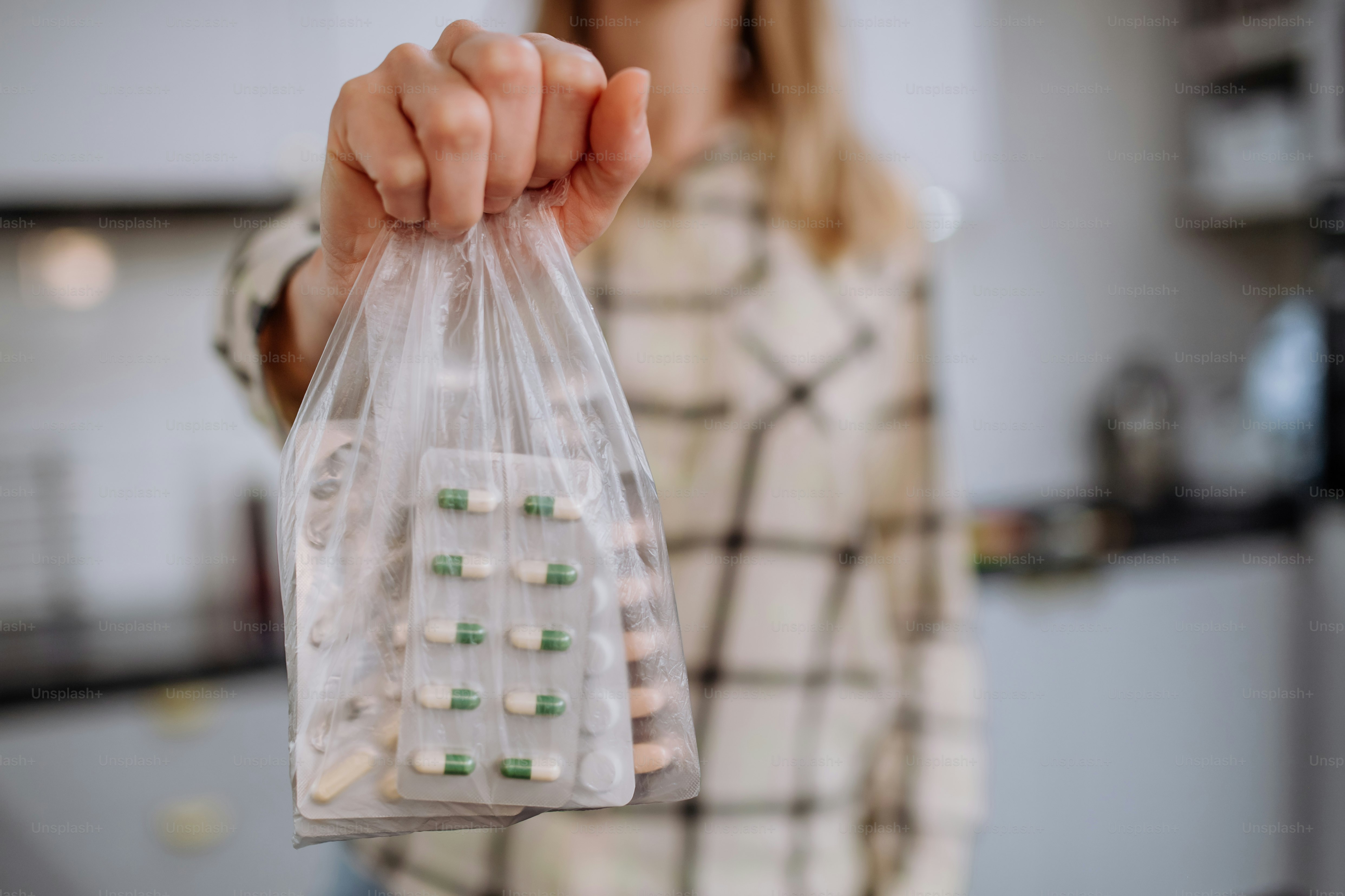 Die Hand einer Frau, die abgelaufene Pillen zum Recyceln bereithält.