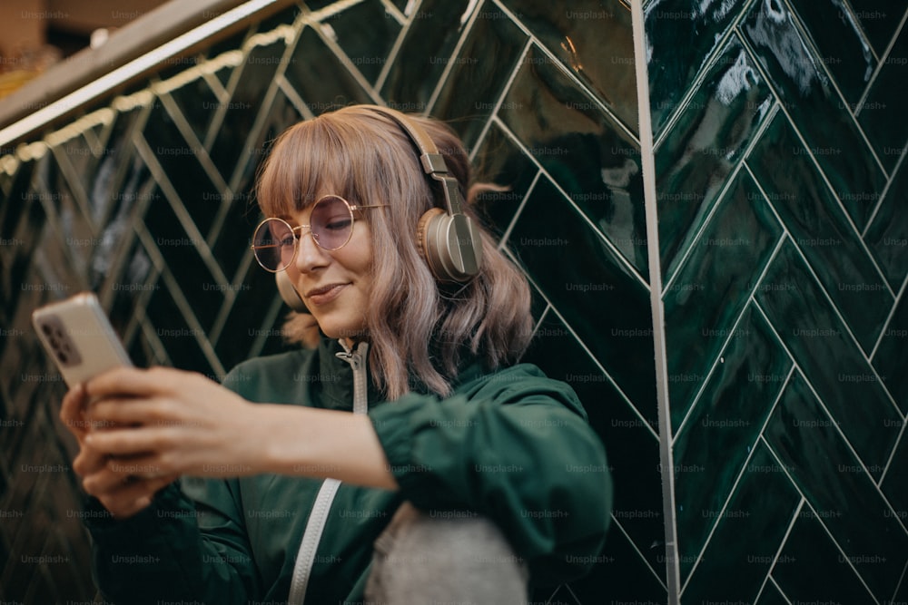 Una mujer joven con auriculares y disfrutando escuchando música en el interior.