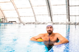 Jugador de waterpolo en una piscina. Hombre haciendo deporte.