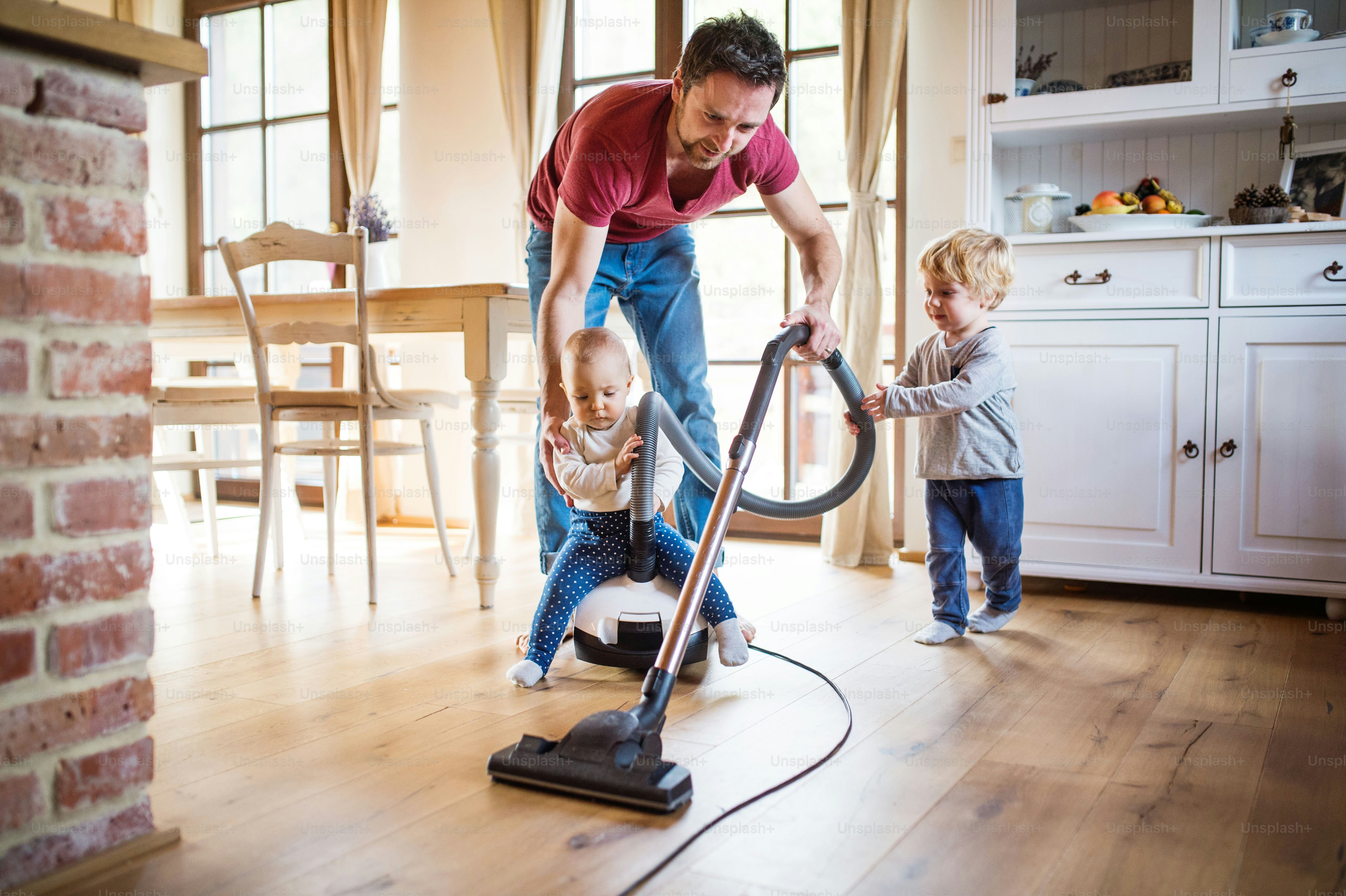 Father and two toddlers doing housework. Paternity leave.