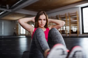 Un retrato de una hermosa joven o mujer haciendo ejercicio en un gimnasio.