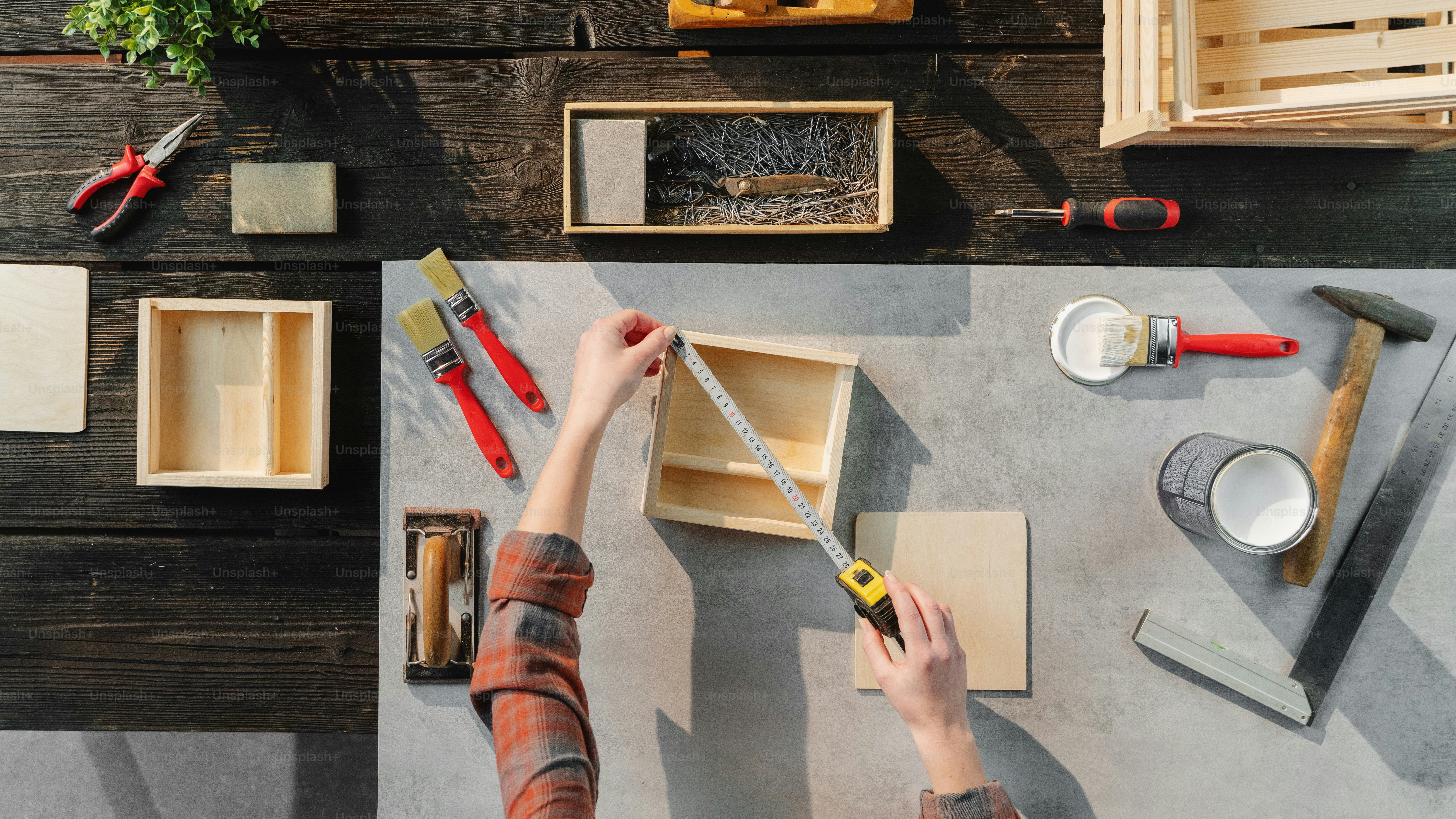 A top view of unrecognizable woman making wooden boxes, small business and desktop concept