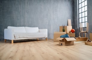 An empty living room with cardbord boxes ready to unpack, moving home concept.