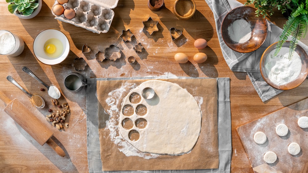 A flat lay top view of dough and baking ingredients, desktop concept.