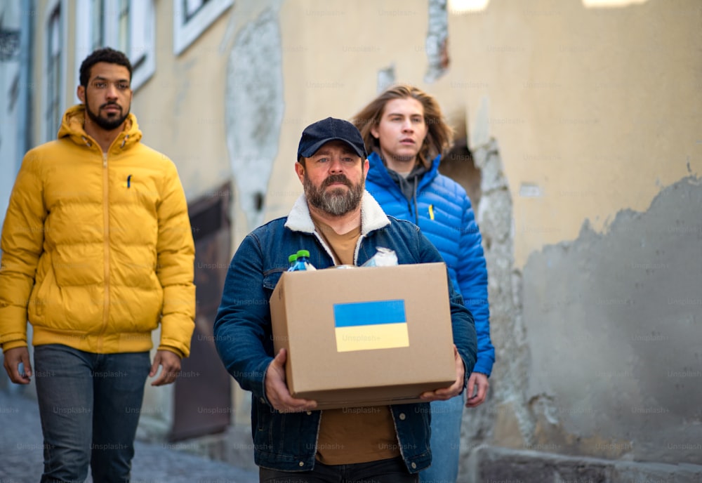 거리에서 우크라이나 난민을위한 인도 주의적 지원이 담긴 상자를 수집하는 자원 봉사자 팀
