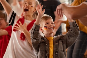 German football fans celebrating their team's victory at a stadium.