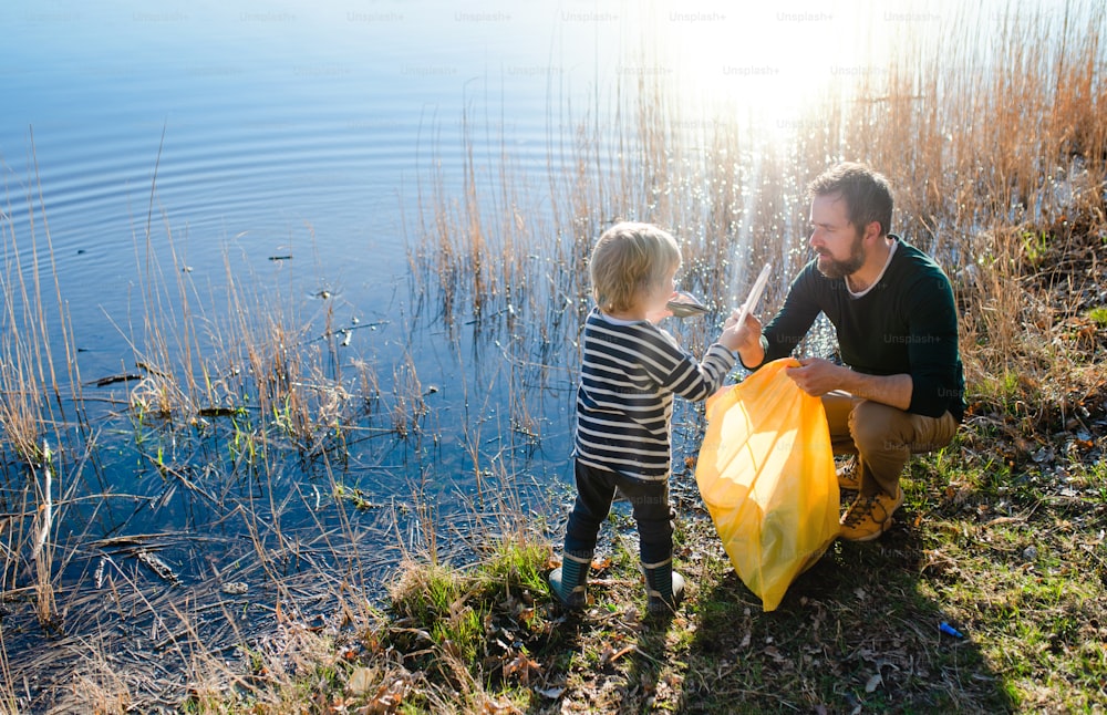 Reifer Vater mit kleinen Kindern, der im Garten arbeitet, nachhaltiges Lifestyle-Konzept.