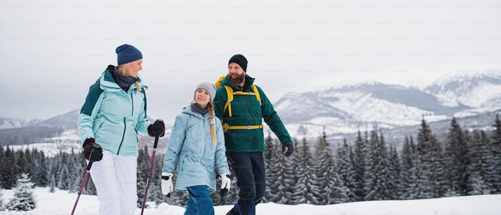 Family with small daughter on a walk outdoors in winter nature, Tatra mountains in Slovakia.