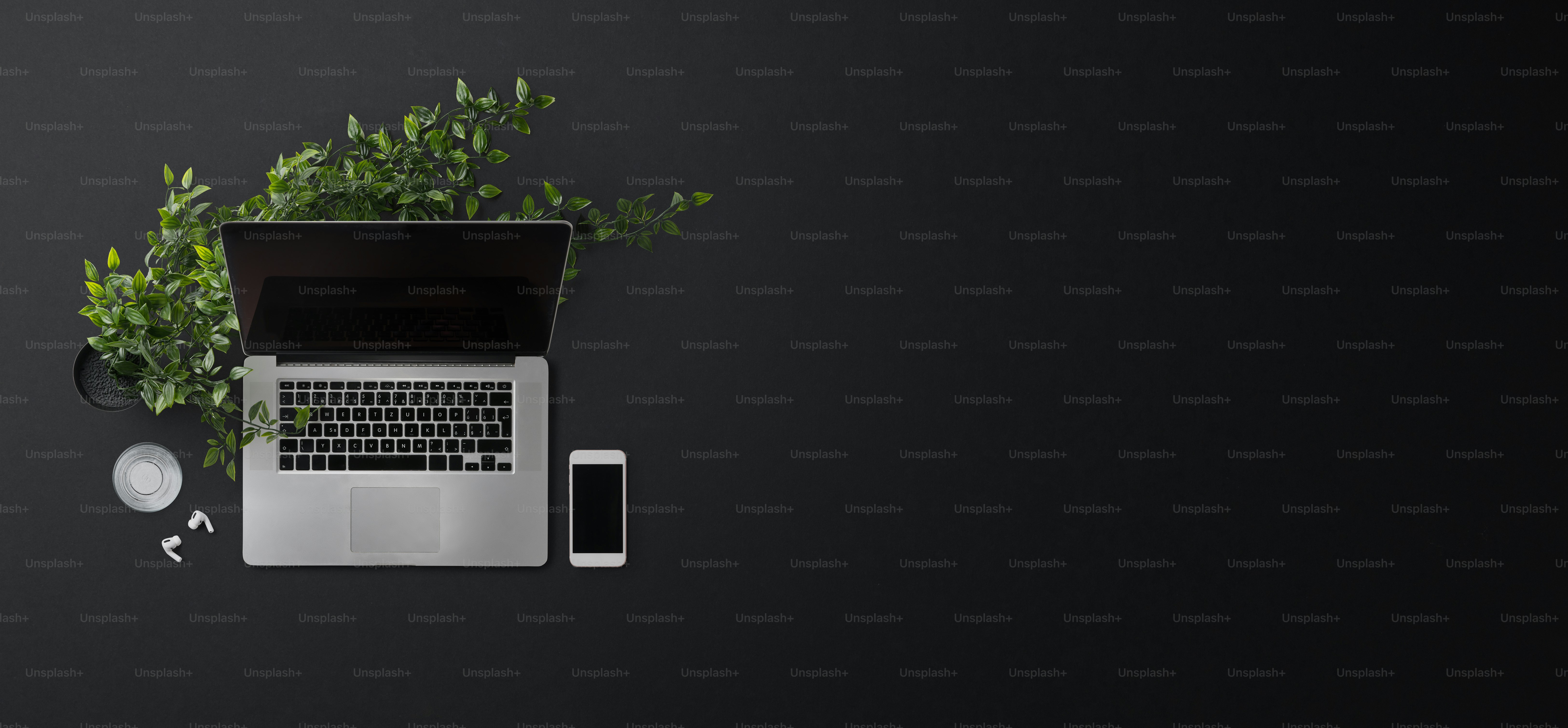 Flat lay top view office desk working space with laptop and smartphone on black background.