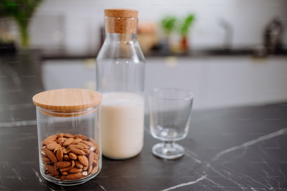 Um leite de amêndoa e vidro no balcão da cozinha. Conceito de produto vegano saudável.