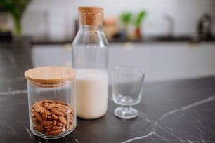 An almond milk and glass on kitchen counter. Healthy vegan product concept.