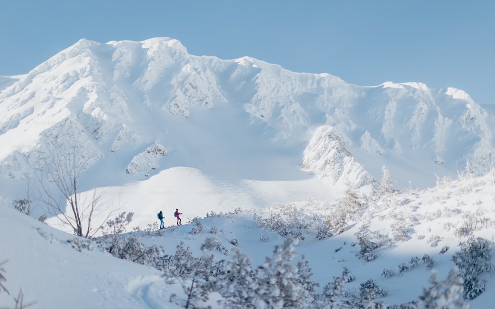 A front view of ski touring couple hiking up a mountain in the Low Tatras in Slovakia.