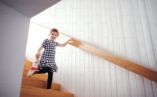 Un bambino piccolo con un peluche che scende le scale. Copia spazio.