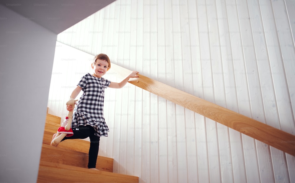 A small child with a soft toy walking down the stairs. Copy space.